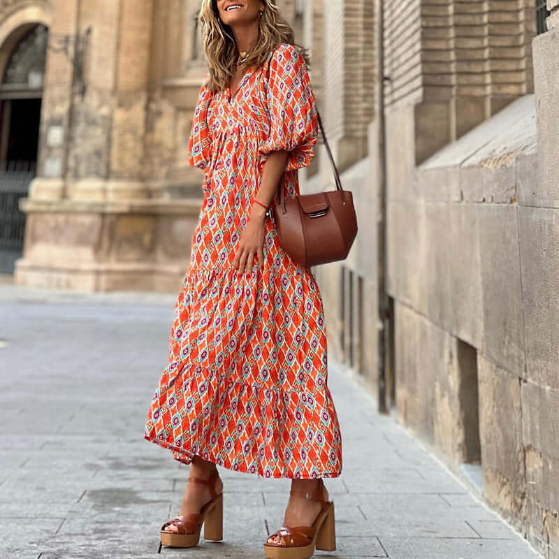 woman wearing British style vintage bohemian floral print summer dress with puff sleeves and V-neck standing outdoors