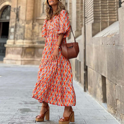 woman wearing British style vintage bohemian floral print summer dress with puff sleeves and V-neck standing outdoors
