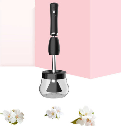 Electric makeup brush cleaning machine with a silicone and plastic design placed against a pink background, accompanied by floral elements.