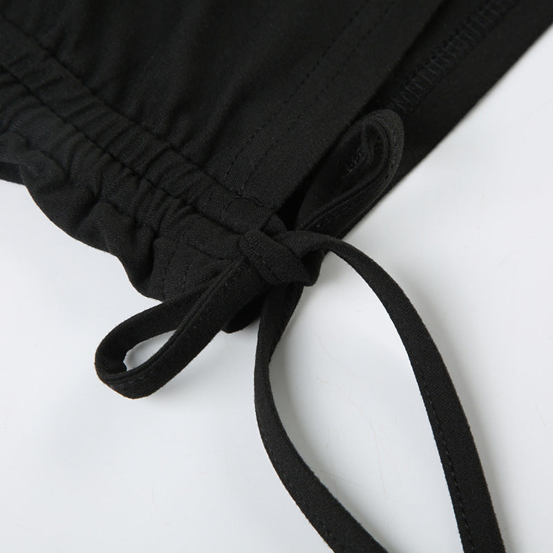 Close-up of black pleating design and lace-up detail on women's off-shoulder jumpsuit sleeve
