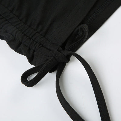 Close-up of black pleating design and lace-up detail on women's off-shoulder jumpsuit sleeve