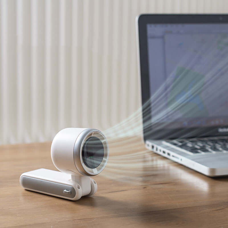 Compact portable mini fan with Type-C input, folding design, and powerful turbo airflow next to a laptop on a wooden desk