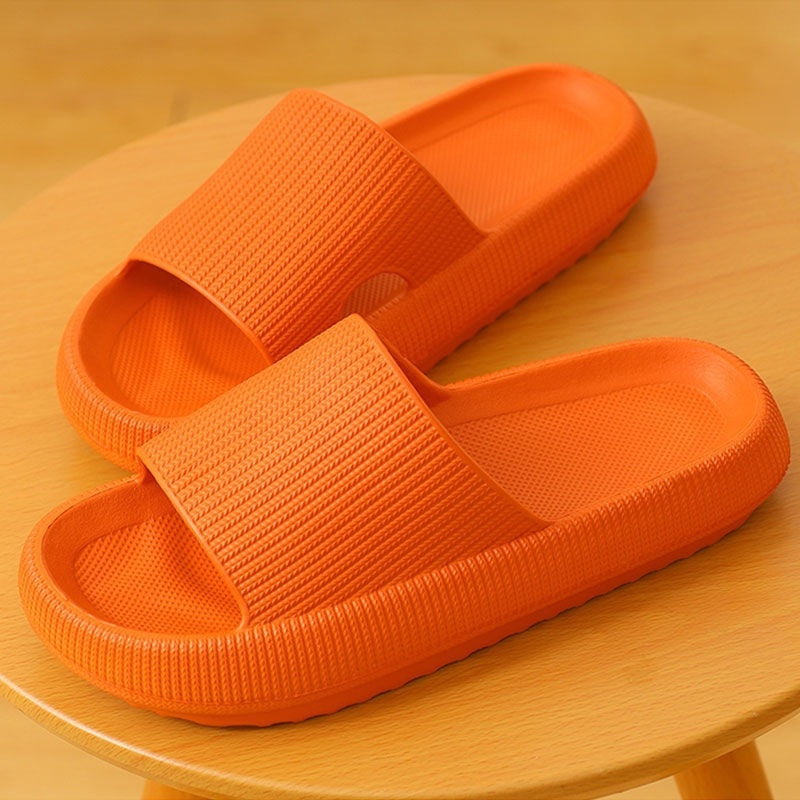 Home household bathroom orange bath sandals on a wooden surface.