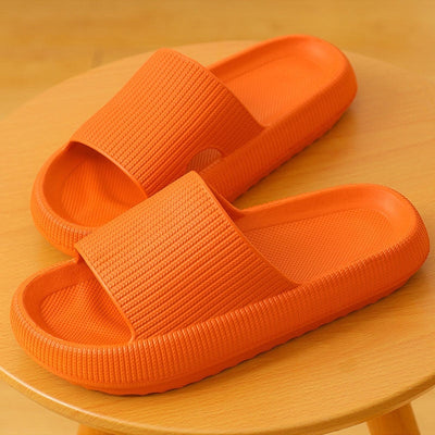 Home household bathroom orange bath sandals on a wooden surface.