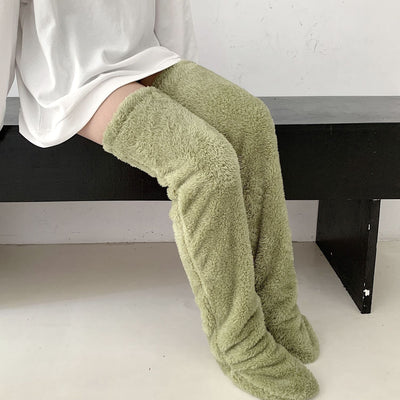 Over knee high fuzzy socks in green, providing warmth and comfort.
