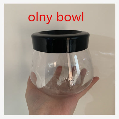 Clear glass bowl with black rim for makeup brush cleaning machine, held in hand.