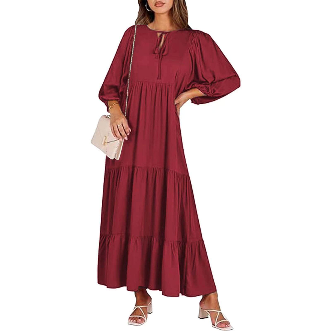woman wearing elegant British style loose long sleeve burgundy bohemian dress with tiers and v-neck, holding beige purse
