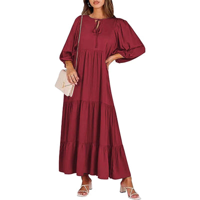 woman wearing elegant British style loose long sleeve burgundy bohemian dress with tiers and v-neck, holding beige purse