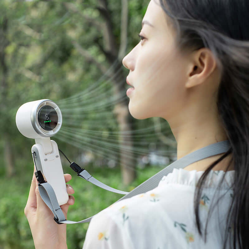 Person using a white portable handheld neck folding mini fan with Type-C input outdoors