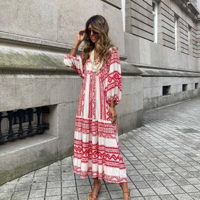 Woman wearing a red and white British style vintage bohemian long dress with loose sleeves and floral pattern on city street